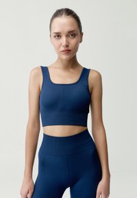 Top corto de canalé en color marino y leggings de talle alto a juego. Con cuello cuadrado, silueta ajustada y tejido texturizado.