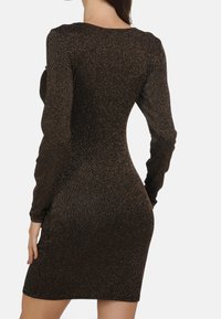 Czarna dopasowana sukienka z długimi rękawami, subtelnym złotym połyskiem, prążkowaną fakturą i okrągłym dekoltem, zaprojektowana tak, aby podkreślać sylwetkę.