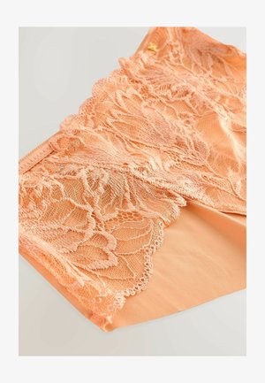 Perzikkleurige lingerie met ingewikkelde kantdetails en gegolfde randen, met een gladde binnenstof en subtiele gouden accenten.