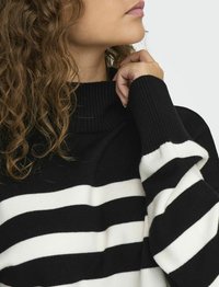 Zwart-wit gestreepte trui met een geribbelde turtleneck, met een losse pasvorm en een zachte, gebreide textuur.