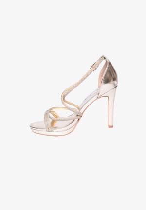 Sandalo argentato con tacco alto, caratterizzato da sottili cinturini scintillanti che si incrociano sul piede e una cinghia alla caviglia con chiusura posteriore.