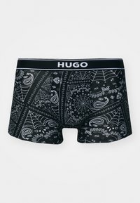 Crne bokserice s bijelim uzorkom paisleyja i paučine, s crnim pojasom na kojem je ispisano ime branda "HUGO."