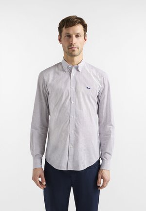 Camicia a maniche lunghe con bottoni, caratterizzata da una base bianca con piccoli pois blu, tessuto morbido e un delicato logo ricamato sul petto.