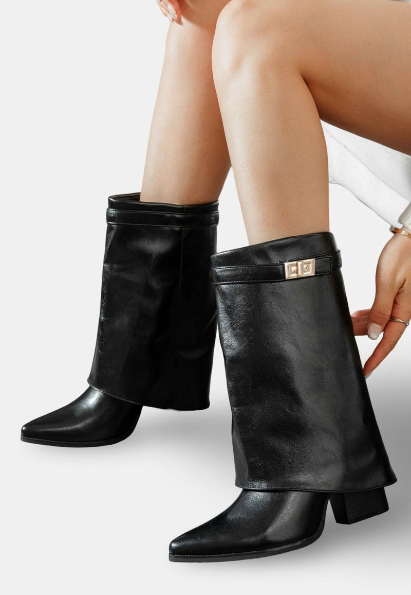 Bottes de cheville en cuir noir avec un revers replié, un bout pointu et un talon carré, dotées d'accents en métal doré sur le revers.