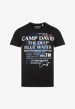 T-shirt nera a maniche corte in cotone; presenta un testo stampato in bianco e blu con vari riferimenti e design geografici.