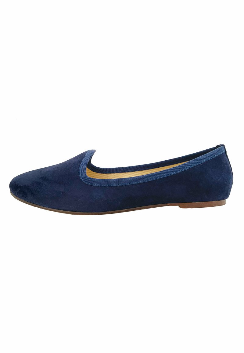 Ballerines en suède bleu marine avec un bout arrondi, présentant un contour léger bleu contrastant le long du col et une petite semelle plate en caoutchouc.