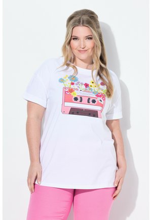 T-shirt en coton blanc avec un graphique de cassette rose agrémenté de fleurs. Manches courtes et coupe décontractée. Assorti avec des leggings roses.