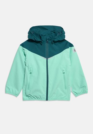 Svetlozelená nepremokavá bunda s tmavomodrým panelom na hrudi a kapucňou, predným zipsom, dvoma vreckami na zips a elastickými manžetami.