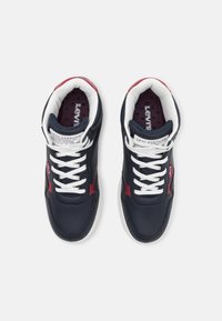 Granatowy sneaker z czerwonymi akcentami, białymi sznurowadłami i teksturowaną wkładką. Wyposażony w wyściełany kołnierz i branding Levi's. Górna część z gładkiej skóry.