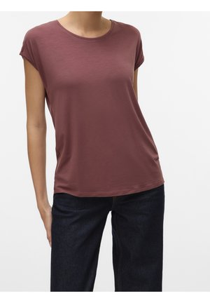 Vrouw draagt een mauve T-shirt met korte mouwen en ronde hals, gecombineerd met donkerblauwe jeans tegen een effen witte achtergrond.