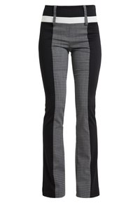 Zwarte en grijze gestreepte broek met een aansluitende taille, voorzien van een witte tailleband en contrasterende zijpanelen. De stof lijkt soepel en rekbaar te zijn.