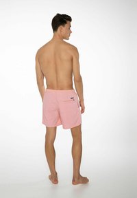 Lichtroze zwembroek met een elastische tailleband, een broekzak aan de achterkant en een eenvoudig design. De stof lijkt soepel en licht van gewicht te zijn.