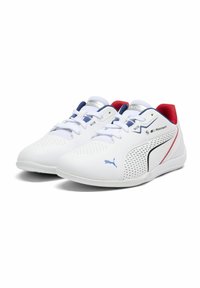 Baskets blanches de sport avec des accents bleus et rouges, matériau perforé sur les côtés et design à lacets ; logo Puma visible sur le côté.