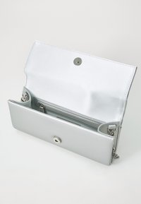 Silberne metallische Brieftasche mit einem Druckverschluss, die ein offenes Design, mehrere Kartenfächer und einen Befestigungsring für eine Kette aufweist. Glatte Textur.