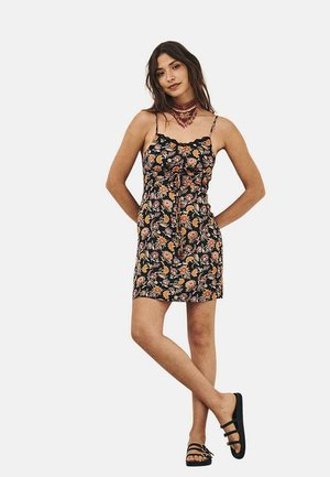 Vestido de estampado floral con tirantes finos, fondo negro, que presenta flores naranjas y rosas. Diseño corto y ajustado con una cintura ajustable.