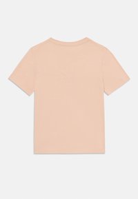 T-shirt de manga curta em tecido pêssego claro, com decote redondo, textura suave e sem padrões ou gráficos visíveis na parte de trás.