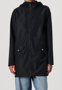 Černá kapucí džínová bunda se zipem vpředu, elastickým pasem a dvěma kapsami na cvoky. Hladký materiál s volným střihem a dlouhými rukávy.