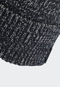 Gorro tricotado em preto e branco com padrão texturizado. Apresenta um pequeno rótulo de marca na borda. Material resistente com um ajuste confortável.