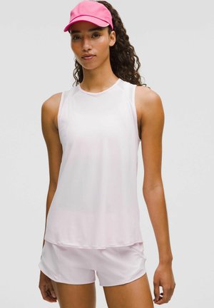 Top deportivo sin mangas en rosa claro y pantalones cortos a juego, hechos de una tela suave y transpirable. Una gorra rosa brillante añade contraste de color.