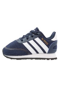 Marinblå nät sneaker med vita ränder, rund tå, gummisula, dekorativ sömnad och en märkesdetalj nära hälen.