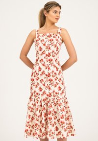 Robe midi florale avec décolleté carré, imprimé de fleurs rouges et oranges sur un tissu blanc, ourlet évasé et détails de boutons sur le devant.