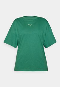 Vihreä ylisuuri t-paita, joka on valmistettu pehmeästä kankaasta. Paidassa on pyöreä pääntie ja lyhyet hihat. Rinnassa pieni vaaleanvihreä logotunnus.