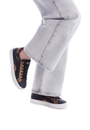 Baskets basses en cuir noir avec des accents en daim marron, un panneau pailleté et un motif léopard. Semelle en caoutchouc blanche et fermeture à lacets.