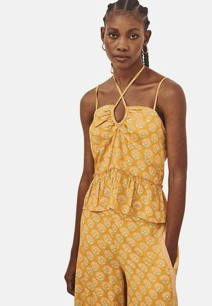 Top floral amarillo con tirantes finos, detalle de abertura, cintura fruncida y dobladillo de peplum. Confeccionado en una tela suave y ligera con un diseño estampado.