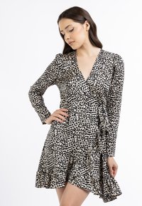 Leopardprint svømme kjole med lange ærmer, V-udskæring og flæset kant. Fremstillet af letvægtsstof med en glat tekstur.