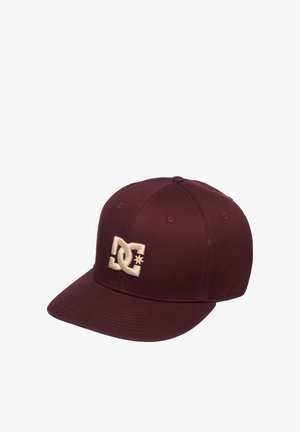 Dark red baseball cap with flat brim featuring an embroidered cream DC logo on the front panel.