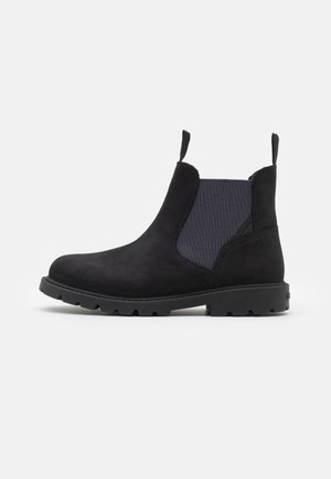 Stivali Chelsea in pelle scamosciata nera con pannelli elastici laterali, linguette e suole in gomma robuste. Presentano un design elegante e minimalista.