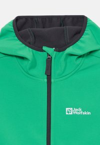 Grønn hettejakke med svart innside og frontglidelås. Har en logo "Jack Wolfskin" i hvitt, med kontrasterende grønn stitching.