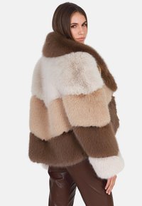 Faux fur jas met verticale strepen in tinten wit, beige en bruin. Zachte textuur met een brede kraag en aansluitende mouwen.