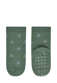 Grüne Socken mit einem Muster aus kleinen grauen Bäumen und roten Punkten. Die Unterseite hat ein strukturiertes Grip-Muster für besseren Halt.