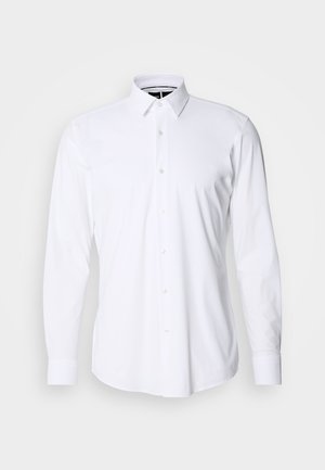 Chemise blanche à manches longues avec boutons, en tissu lisse, dotée d'un col pointu et d'une coupe régulière. Présente une patte de boutonnage à l'avant avec six boutons.