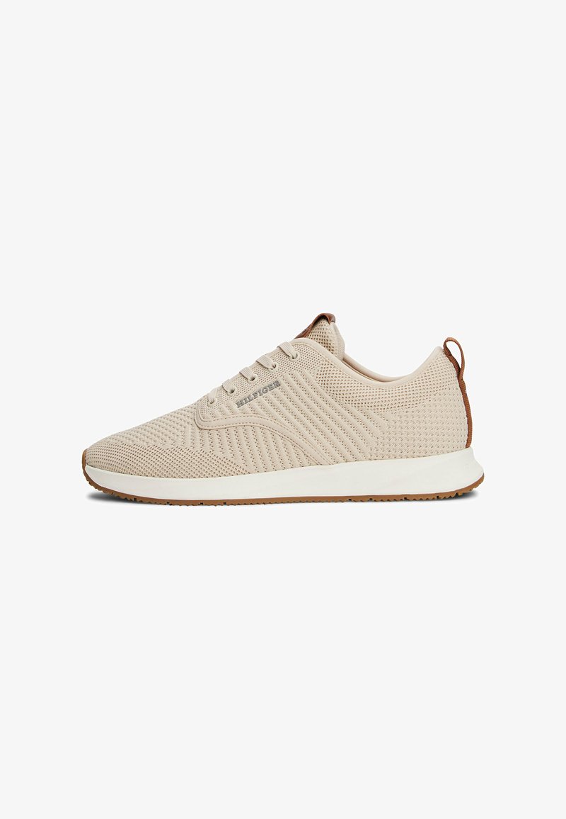 Beige Sport-schuhe mit einem Mesh-Obermaterial, strukturierten Mustern, weißer Zwischensohle und Gummisohle. Verfügt über braune Akzente und ein Schnürdesign.