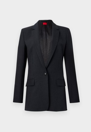 Blazer nero a righe con reverse, chiusura a un bottone, due tasche anteriori e fodera testurizzata. Presenta spalle strutturate e vestibilità sartoriale.