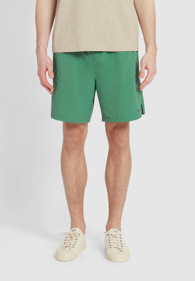 Pantaloni corti verdi realizzati in materiale leggero, con una vita elasticizzata, tasche laterali e un orlo che si ferma sopra il ginocchio.