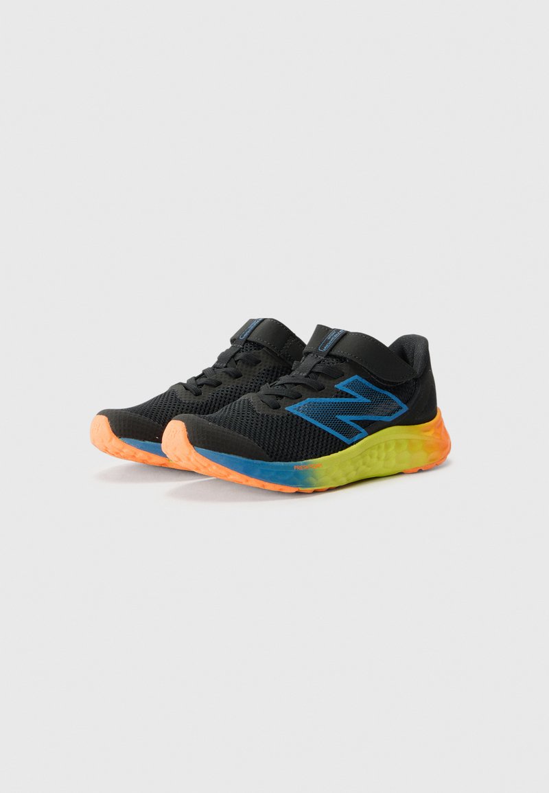 Zapatillas deportivas negras con logo azul, punteras naranjas y mediasoles en degradado naranja-amarillo sobre un fondo blanco liso.