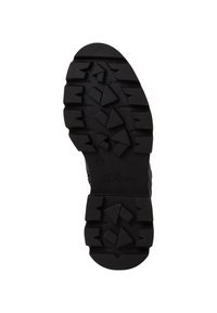 Semelle en caoutchouc noir avec un motif de bande de roulement épais et texturé comportant des formes triangulaires et angulaires. Marquée "s. Oliver" et taille 37.