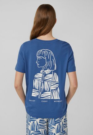 T-shirt en coton bleu à manches courtes, avec une illustration graphique blanche d'une femme au dos et le texte "PROFITEZ DE CHAQUE INSTANT".