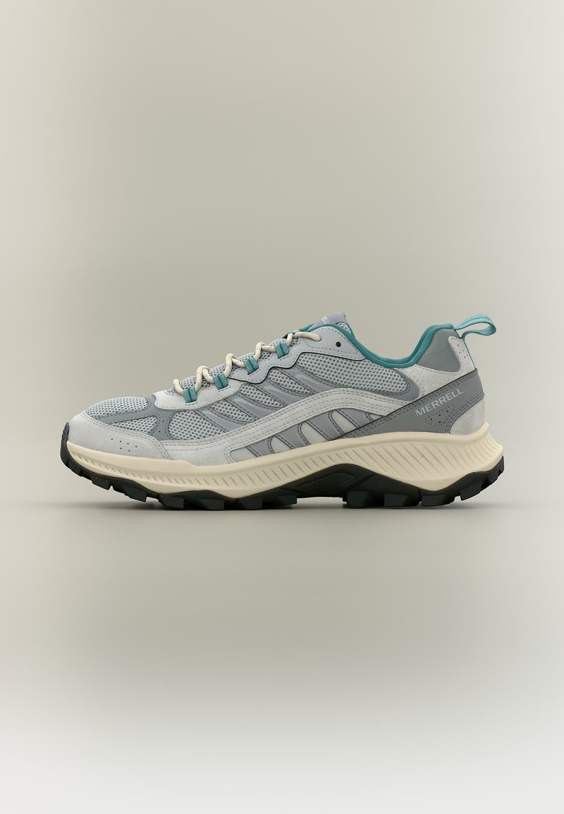 Ανοιχτό γκρι και τιρκουάζ παπούτσι δρόμου Merrell με επάνω μέρος από διχτυωτό ύφασμα και σουέτ, παχύ μπεζ ενδιάμεσο πέλμα και μαύρη ανθεκτική εξωτερική σόλα.