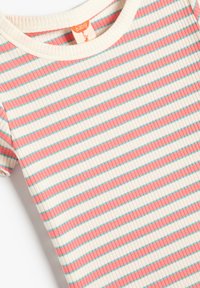 Camiseta de bebé de canalé con mangas cortas, cuello redondo y rayas horizontales en rosa y verde azulado sobre un fondo crema.