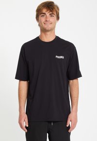 T-shirt nera a maniche corte realizzata in un tessuto morbido e leggero, con un badge logo bianco sul lato sinistro del petto. Design semplice e classico.