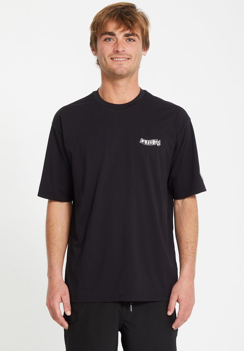 T-shirt nera a maniche corte realizzata in un tessuto morbido e leggero, con un badge logo bianco sul lato sinistro del petto. Design semplice e classico.