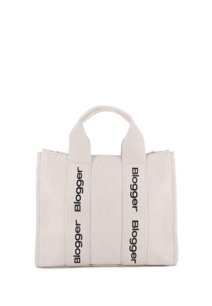 Bolsa tote de lona beige con dos asas, con texto negro vertical "Blogger" impreso repetidamente en las correas.