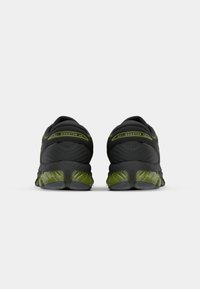 Črne športne čevlje z zelenimi poudarki, ki imajo oblazinjen petni del in teksturiran podplat. Namenjeni udobju s sleek, aerodinamično obliko.