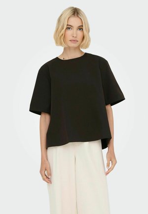 Sort kortærmet top med rund halsudskæring og drop shoulders, der har en løs pasform og glat tekstur. Sammen med lysebeige bukser.
