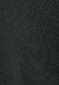 Ciemnozielona dzianina o miękkiej fakturze, z delikatnym wzorem i lekkim połyskiem na całej powierzchni. Brak widocznych elementów metalowych czy ozdobników.