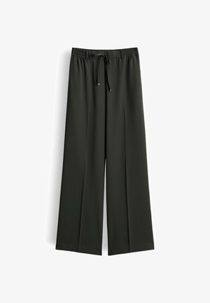 Schwarze Hose mit weitem Bein, elastischem Bund und Kordelzug, keine sichtbaren Taschen, glatter Stoff, vor weißem Hintergrund gezeigt.